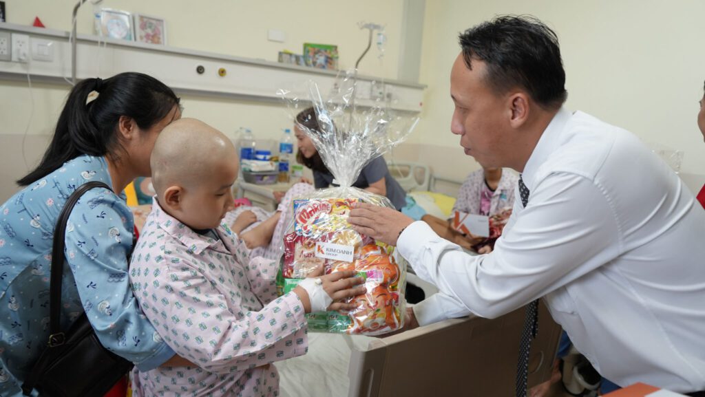 Ông Nguyễn Lương Thọ – Phó Tổng Giám đốc Vận hành Tập đoàn tặng quà cho một cháu bệnh nhi tại khoa điều trị